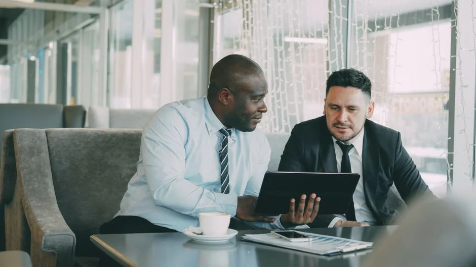 man-standing-in-front-of-people-sitting-beside-table-with-laptop-computers-gmsnxqiljp4